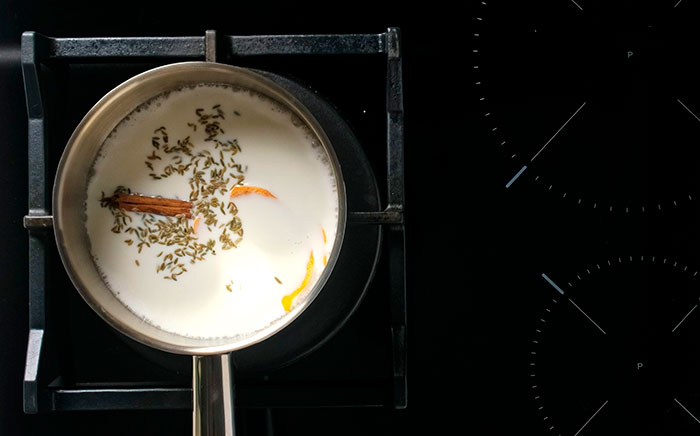 Milk with spices in a saucepan over heat