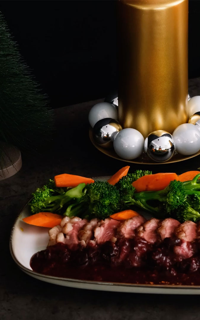 dish with sliced duck breast and Christmas decoration
