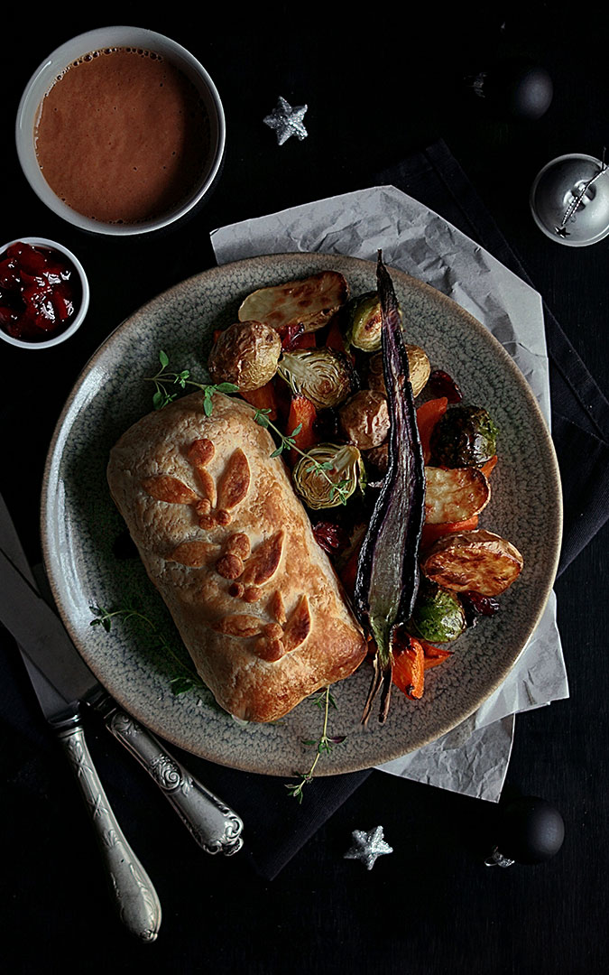 Vegan seitan Wellington with roasted veggie garnish and sauces