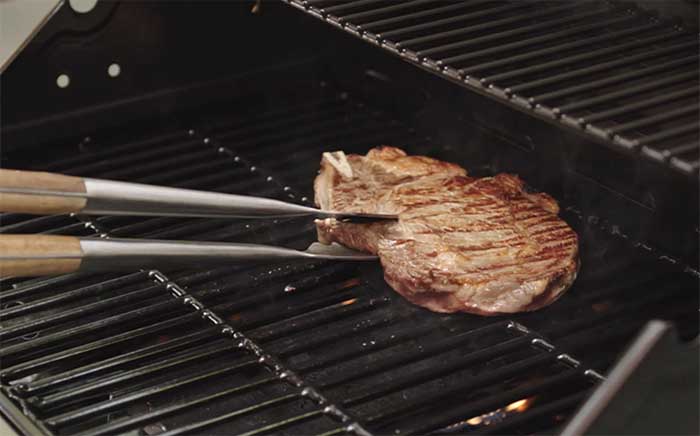 Chuleta en barbacoa de gas Teka sujeta con pinzas