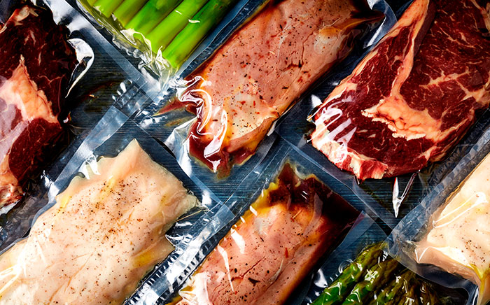 Carnes, verduras y otros alimentos envasados al vacío  sobre una encimera