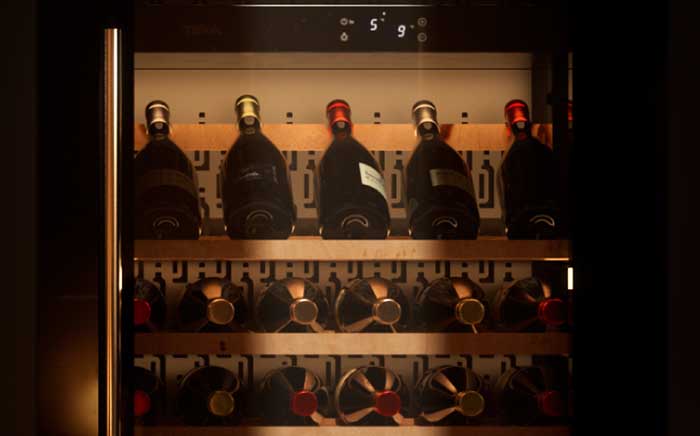 Interior vinoteca Teka Sommelier con botellas dispuestas en baldas de madera