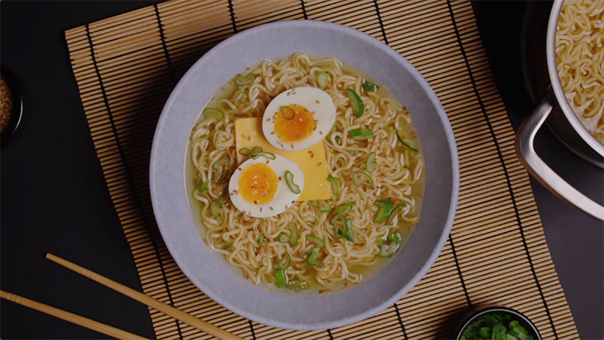 Un tazón de ramen con una cuchara que tiene la palabra ramen.